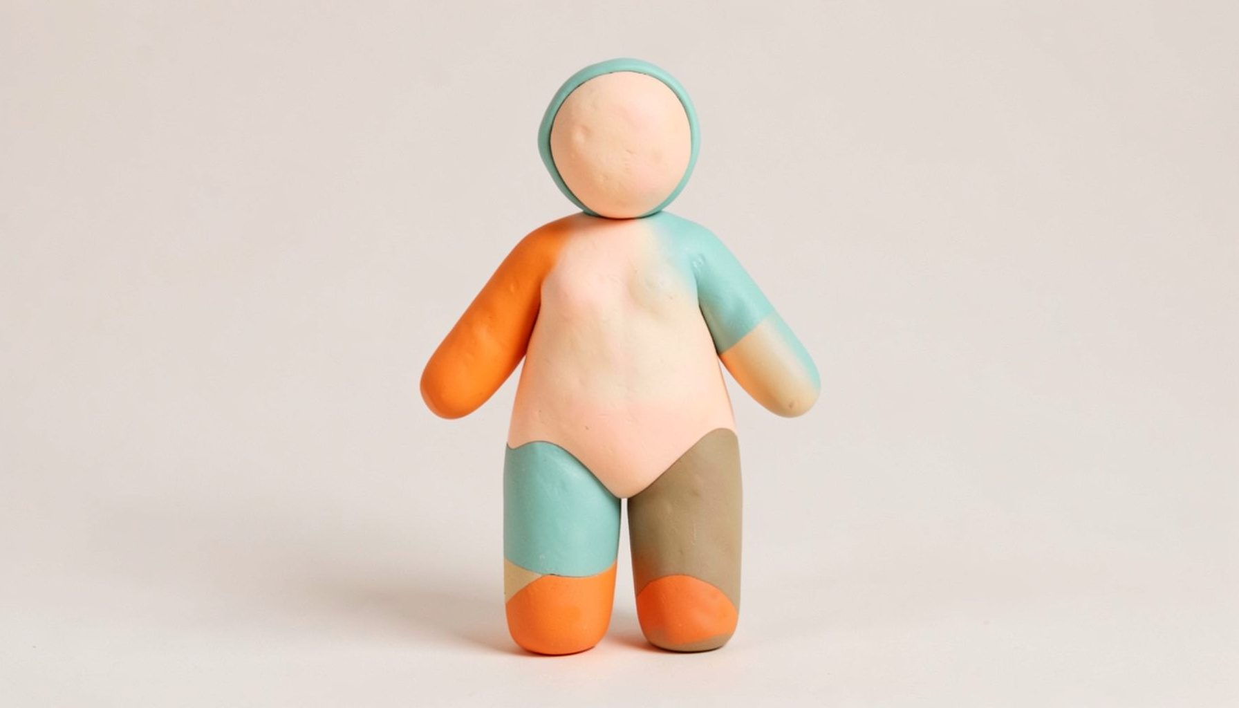 Soft clay-model of a balanced human figure with gentle rounded proportions, in soft peach and teal